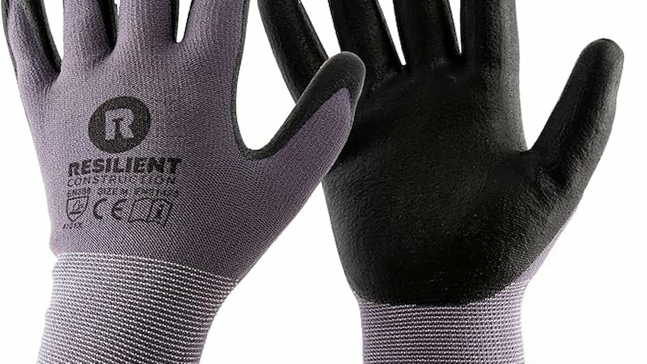 A pair of work gloves, featuring a grey fabric back and black rubber-coated palms, labeled "RESILIENT Construction" with certification markings on the back