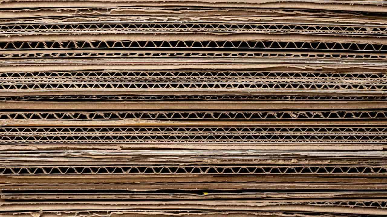 Close-up view of stacked corrugated cardboard layers, showcasing the wavy inner structure and brown paper surfaces