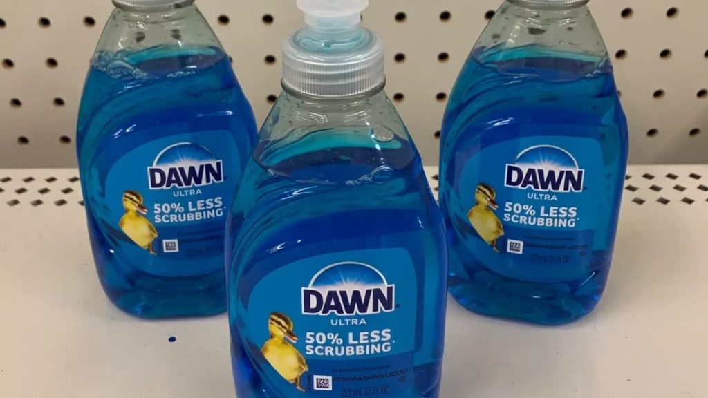 Three bottles of Dawn Ultra dish soap with "50% Less Scrubbing" claim displayed on store shelf