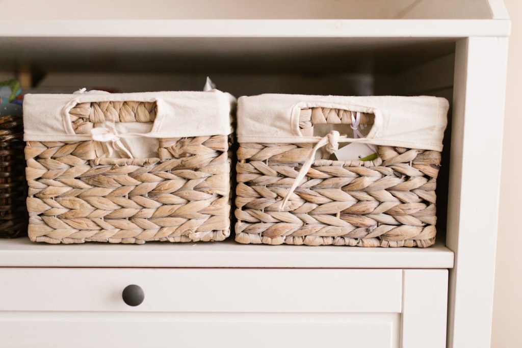 two woven storage baskets with fabric lining on a white shelf, used for organized home storage or decluttering