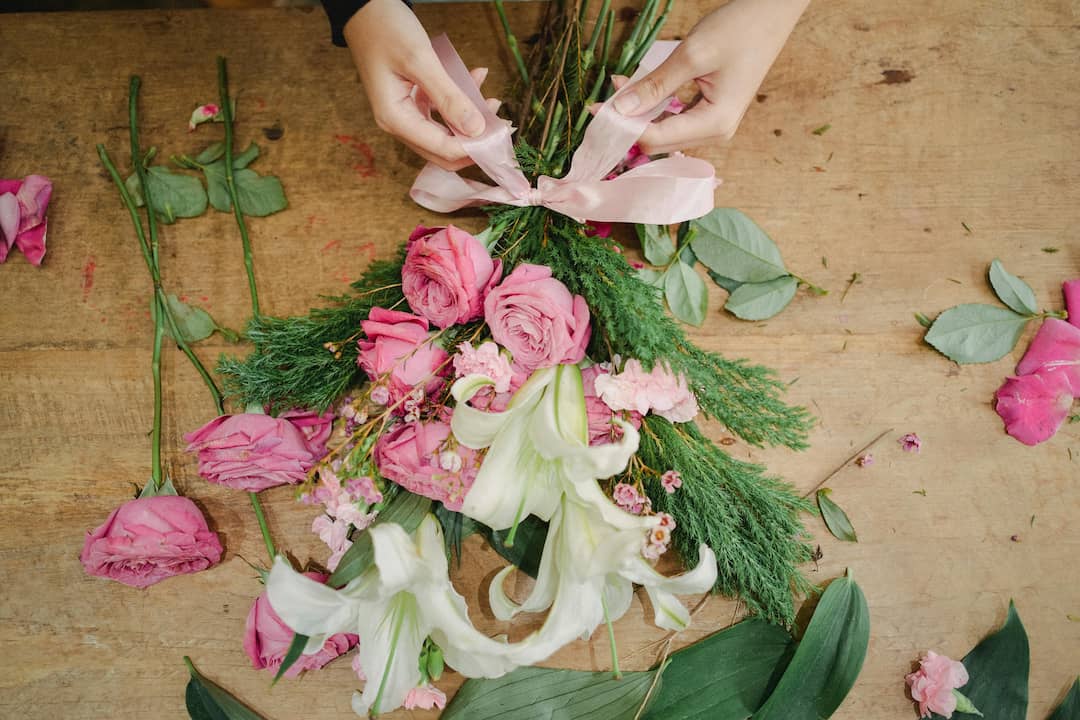 Close-up of a bouquet featuring pale yellow roses surrounded by dense clusters of small white baby’s breath flowers