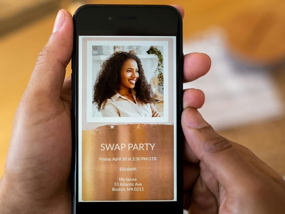 Hand holding a smartphone displaying a digital invitation for a swap party with a photo of a smiling woman, event details listed below