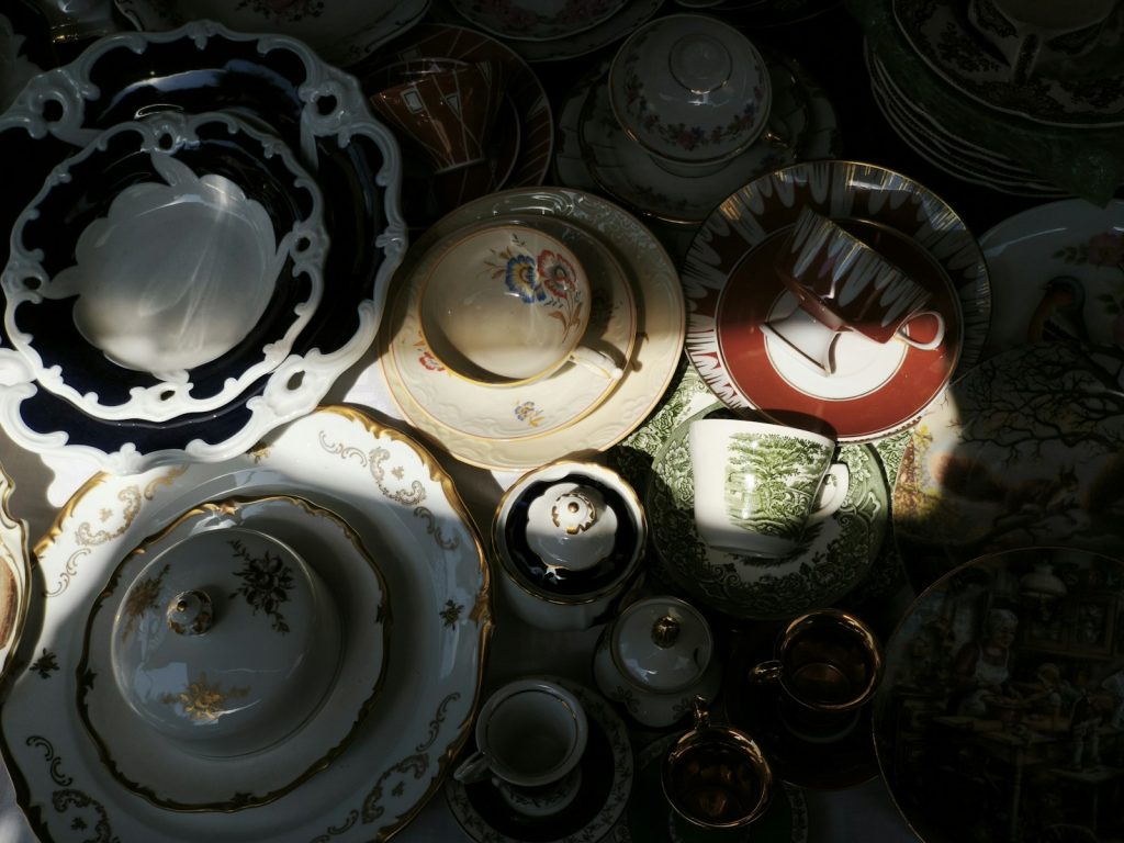 Antique dishes and teacups are arranged close together.