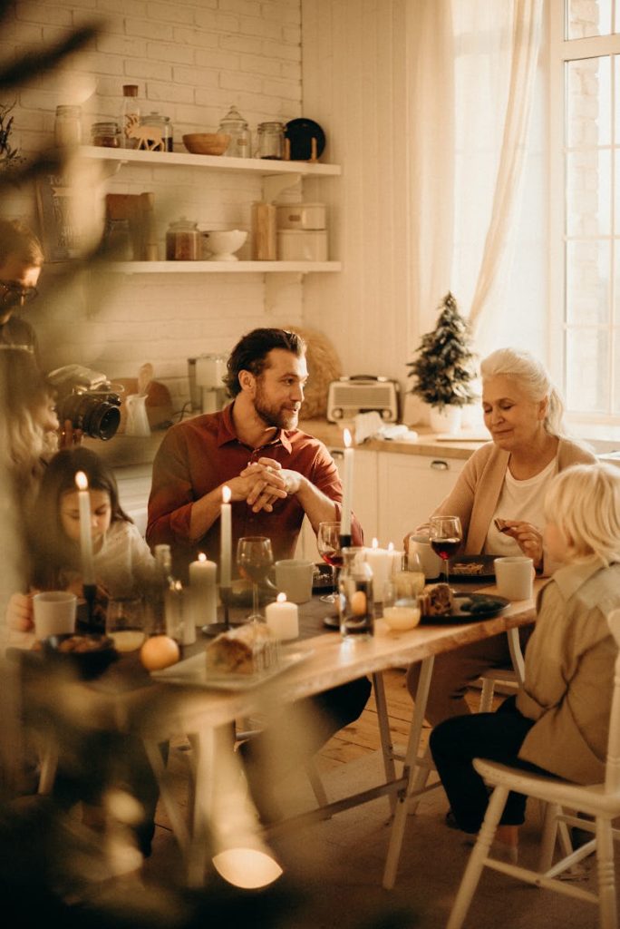 Family enjoying a warm holiday dinner together with candles and laughter.