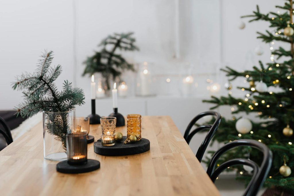 Cozy and elegant dining table decor for Christmas featuring candles and festive ornaments.
