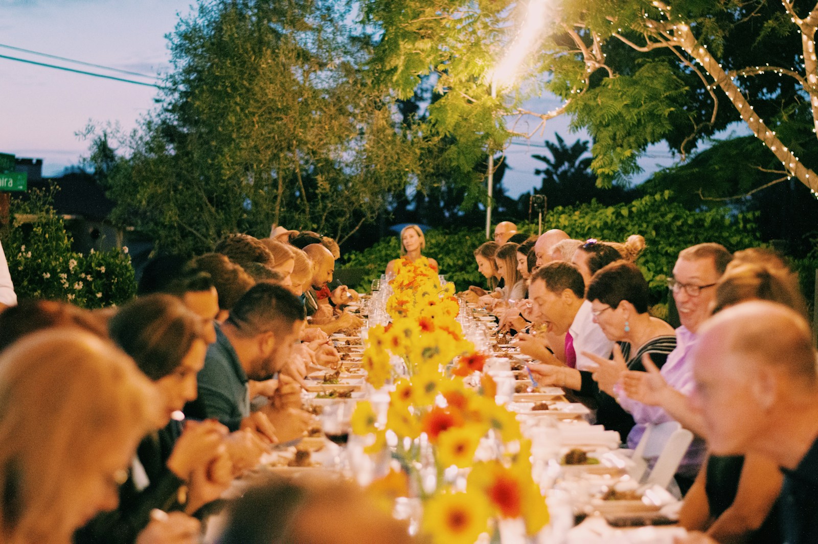 a group of people sitting at a long table