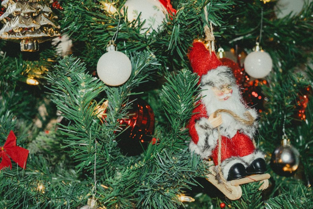 Close-up of a decorated christmas tree with santa ornament.