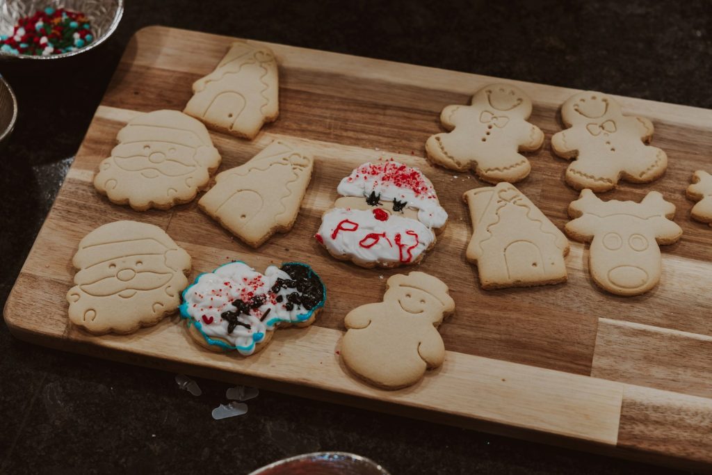 A wooden cutting board topped with lots of cookies