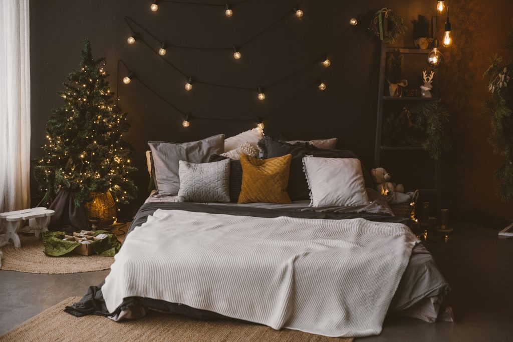 a bedroom decorated for christmas with a bed and a christmas tree