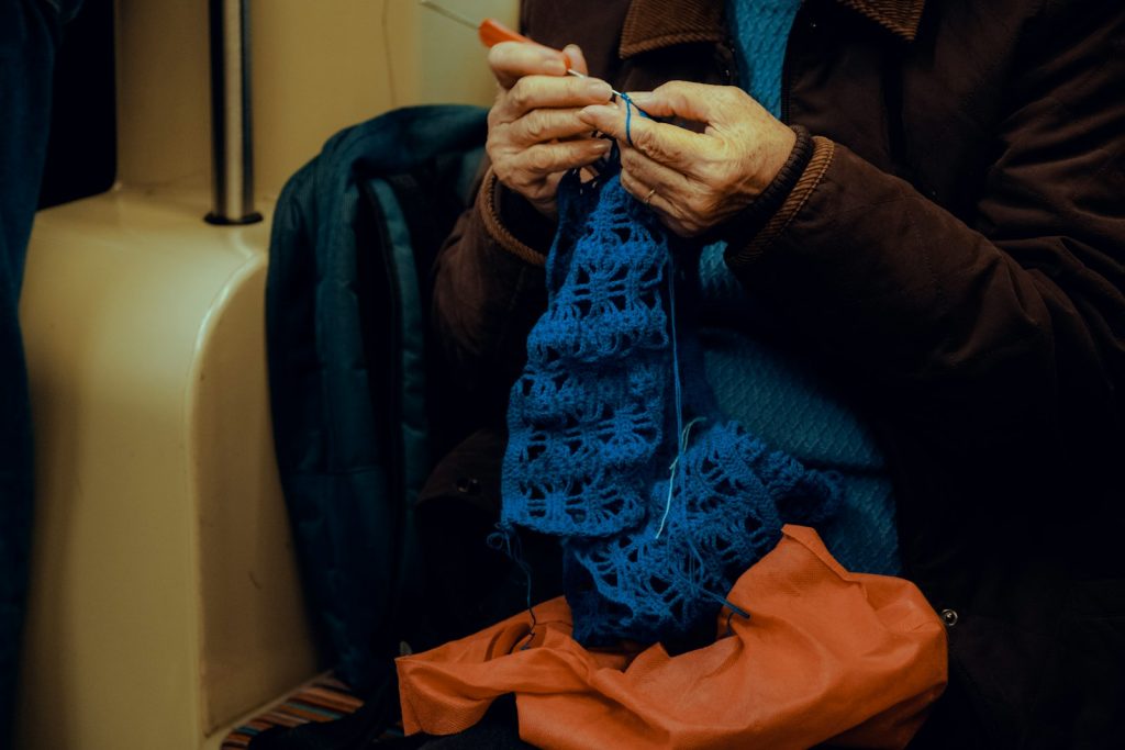 a woman is knitting a piece of cloth