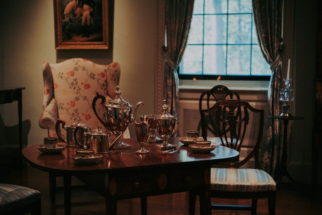 Antique tea set on a table with chairs.