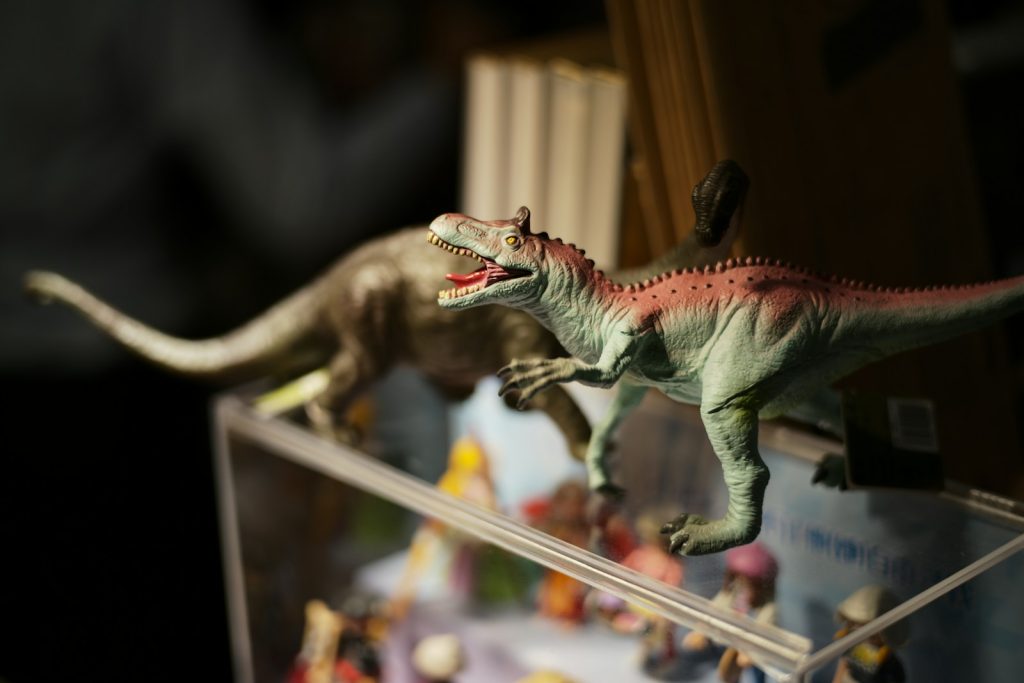 Two dinosaur figurines in a display case