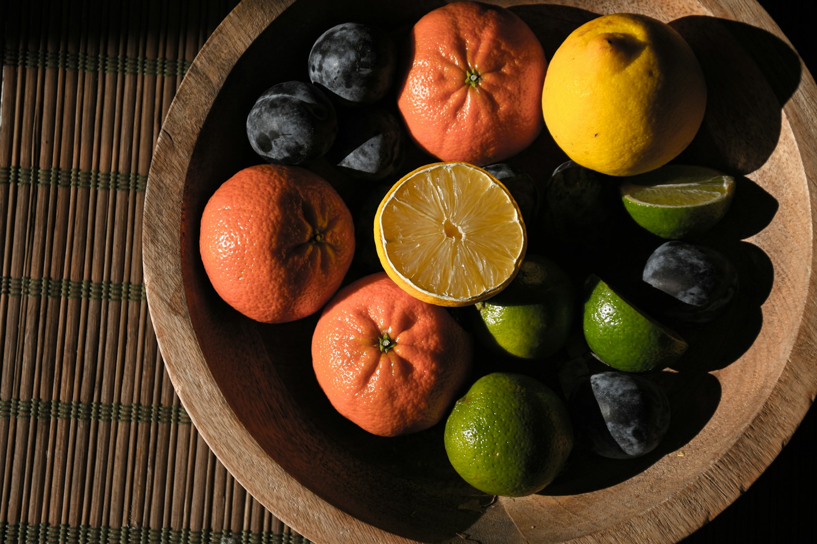 A wooden bowl filled with fruit on top of a table