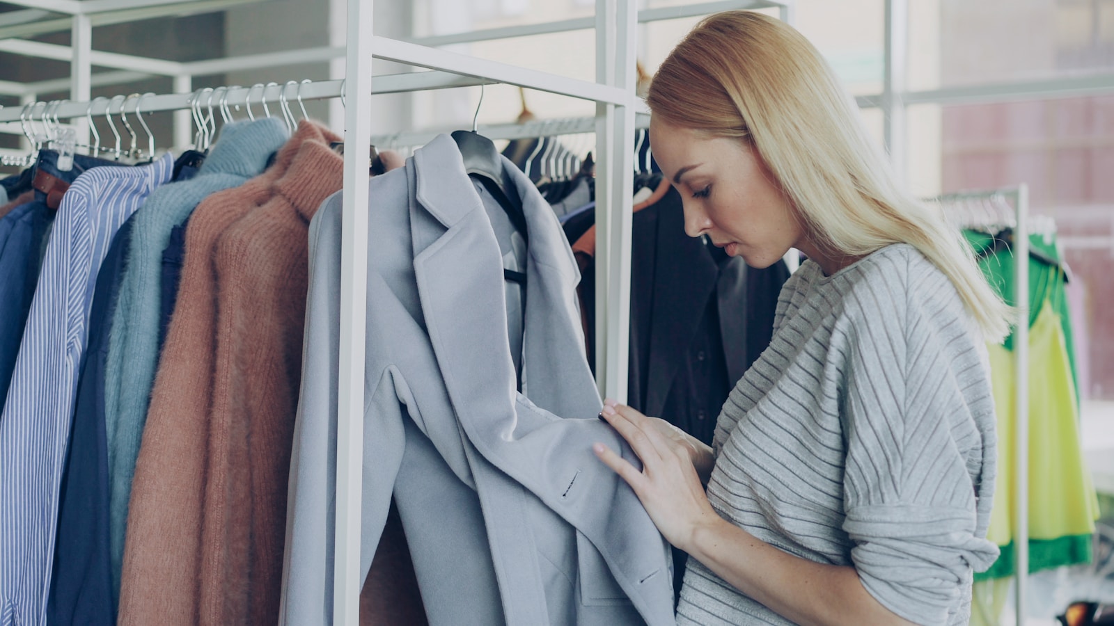A woman looks at clothing on a rack.