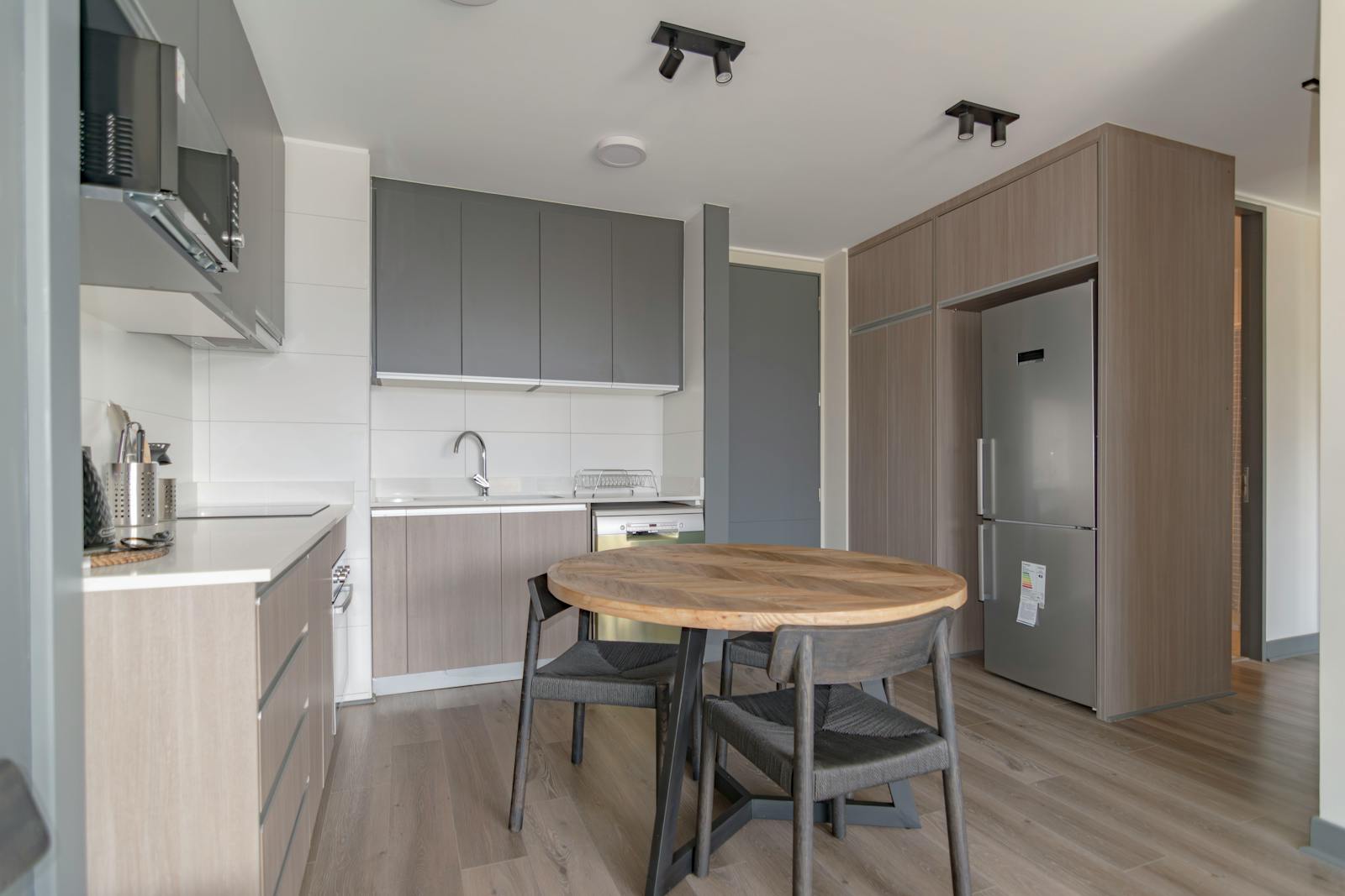 Sleek kitchen interior design featuring wooden furniture and stainless steel appliances.