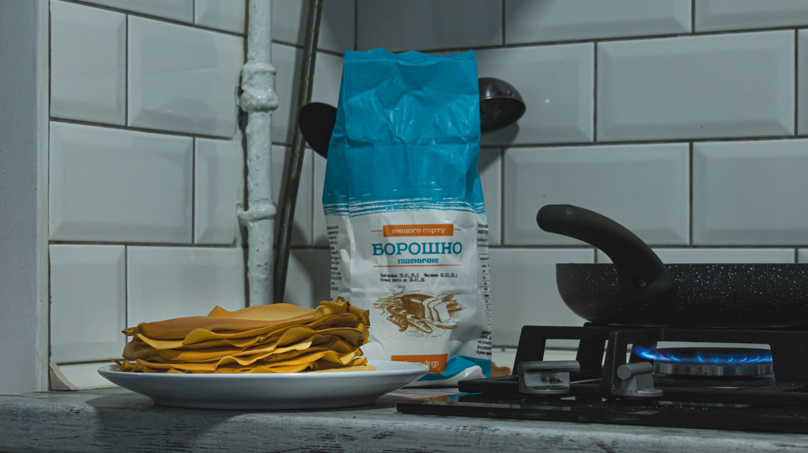 Pancakes, flour, and a pan on the stove.