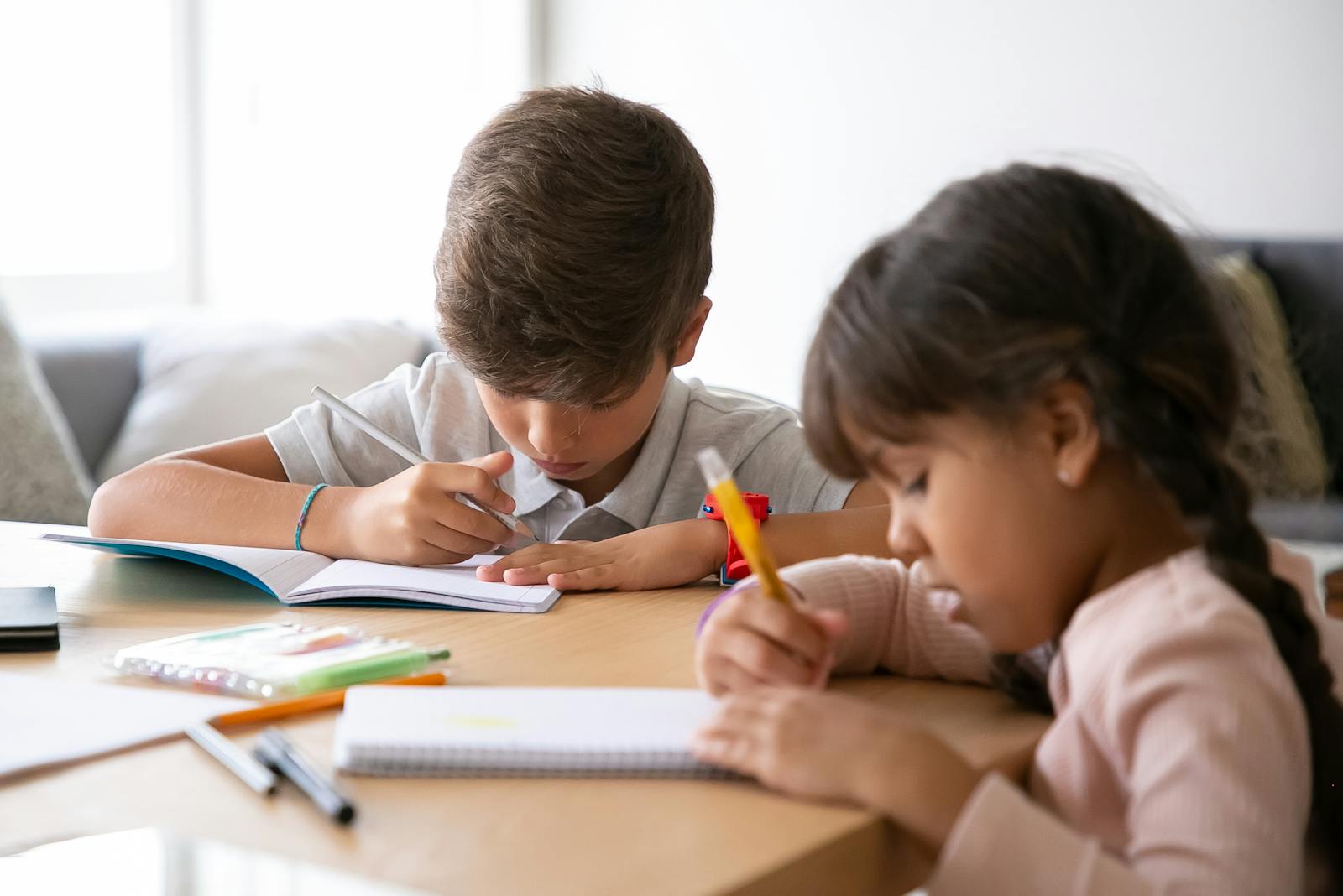 Two children studying together at home, focused on their schoolwork.