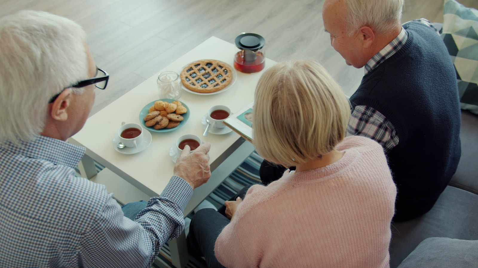 Three seniors enjoying tea and pie together