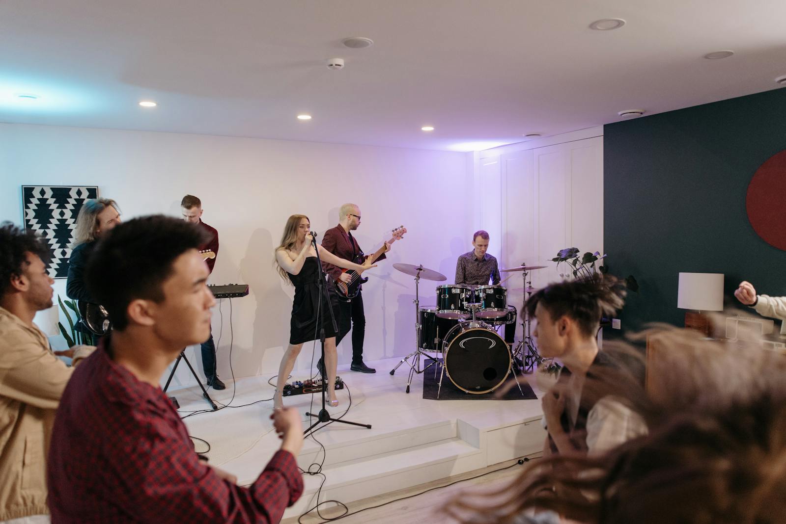 Energetic band performing at a house party with dancing audience. Ideal for music events.