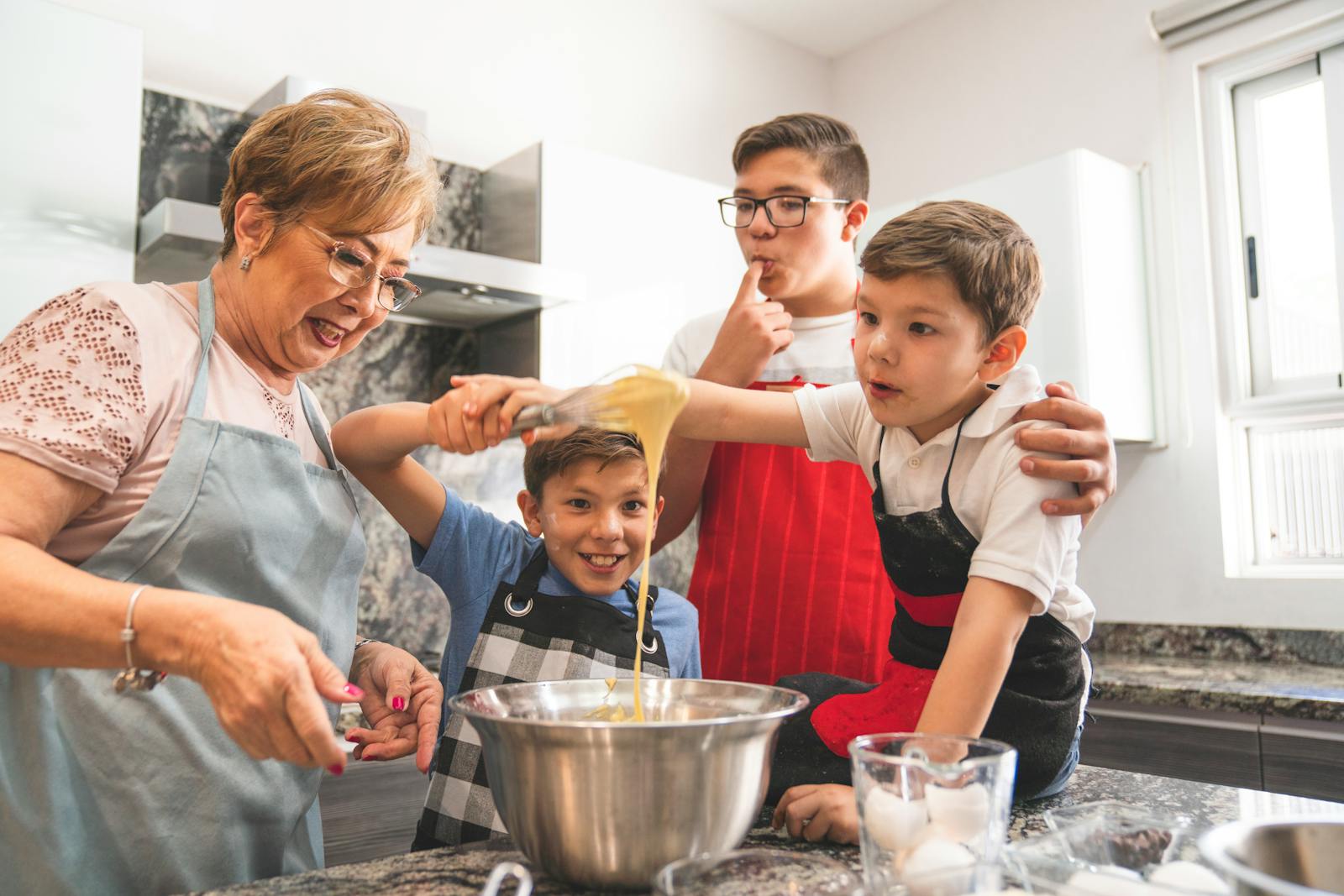 Grandmother and grandsons enjoy baking together, creating special memories in the kitchen.