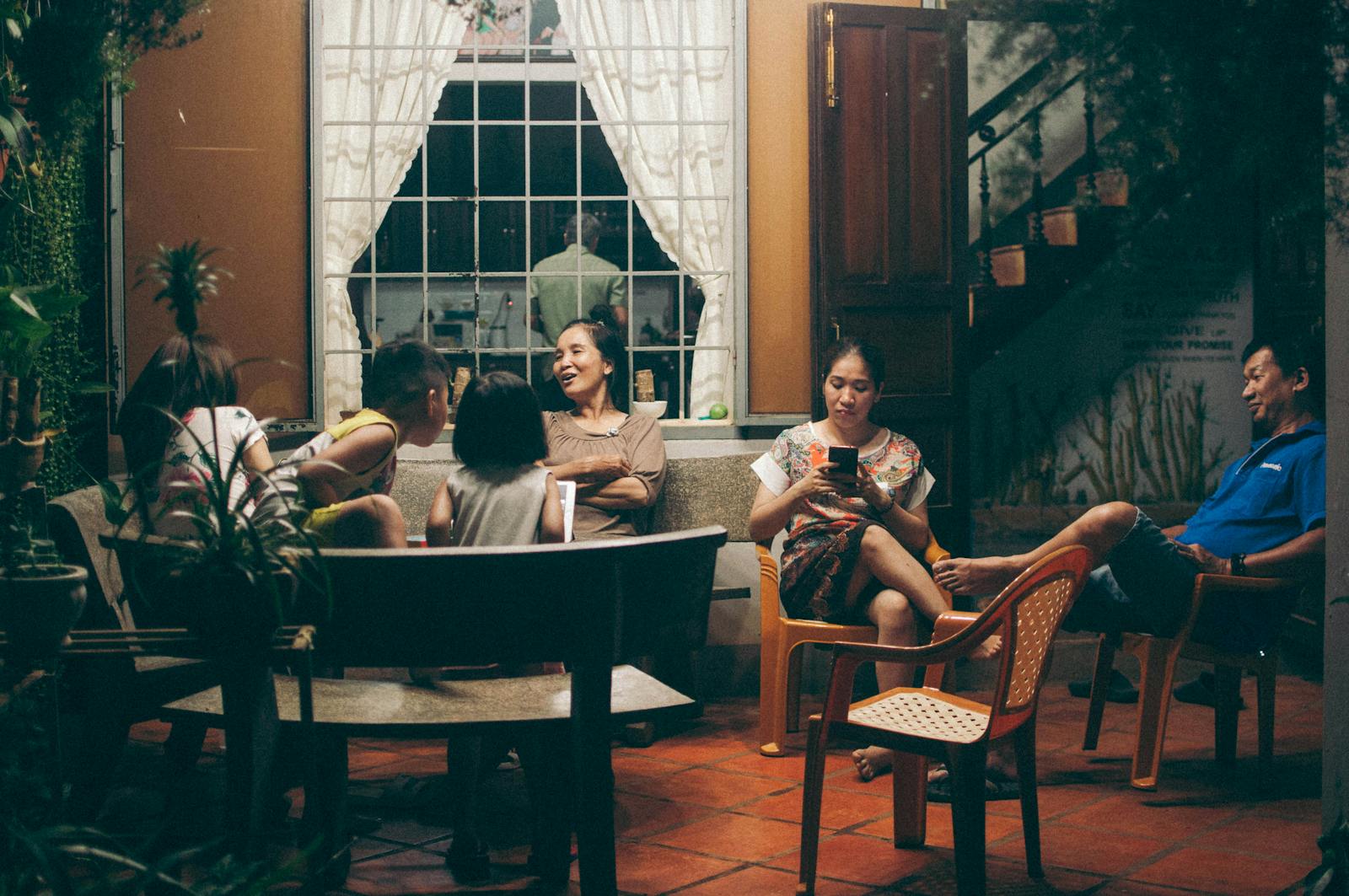 A warm evening family gathering on a porch in Vietnam, with lively conversations and bonding moments.