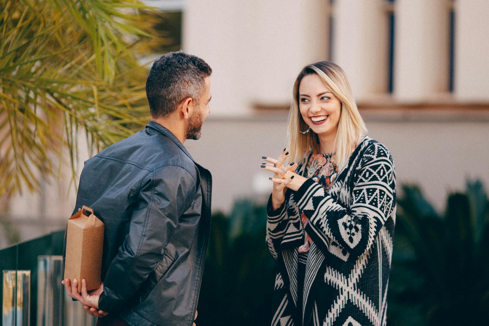 A couple shares a joyful moment outdoors with a surprise gift.