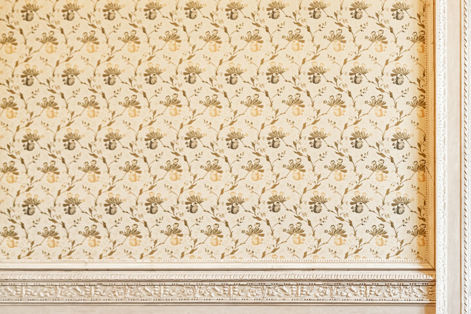 a white and gold wall with a clock on it