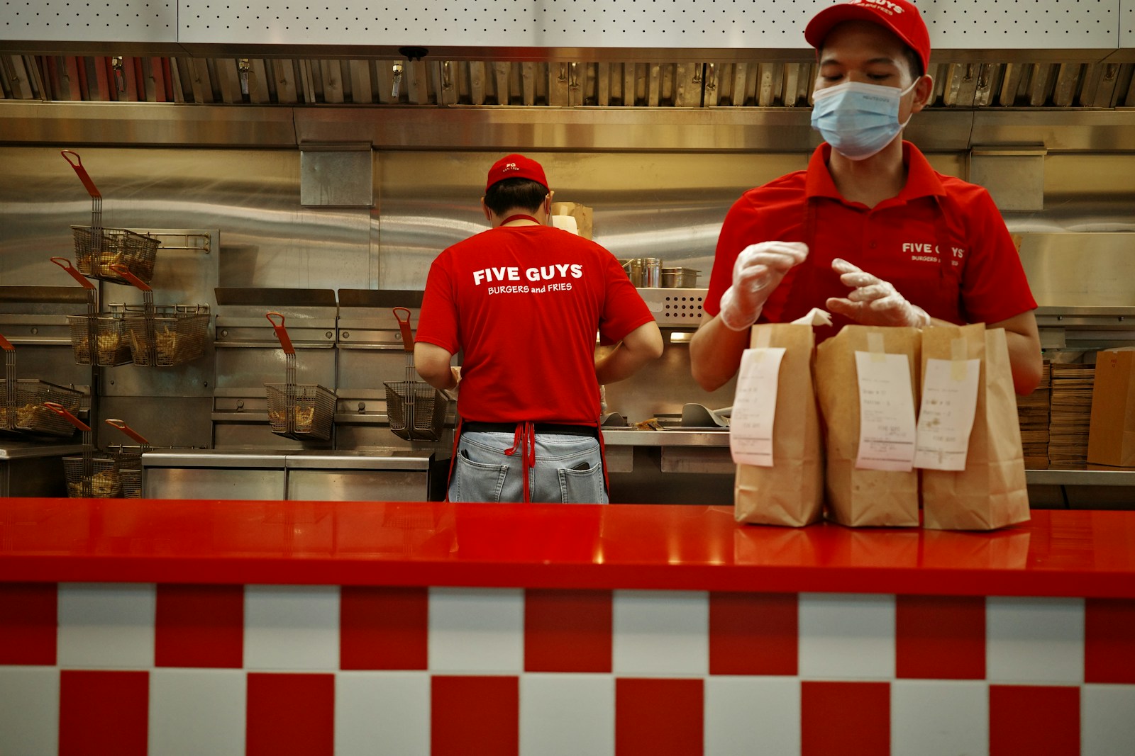 A man wearing a face mask standing behind a counter