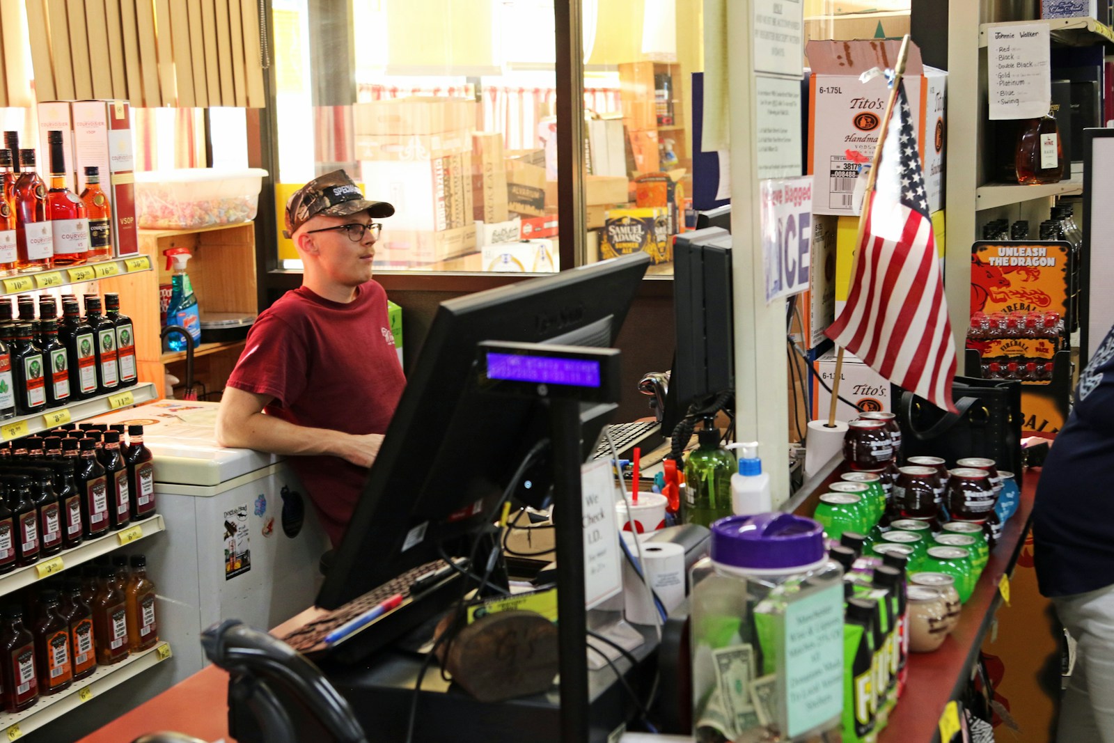 Young man working at a store checkout counter.