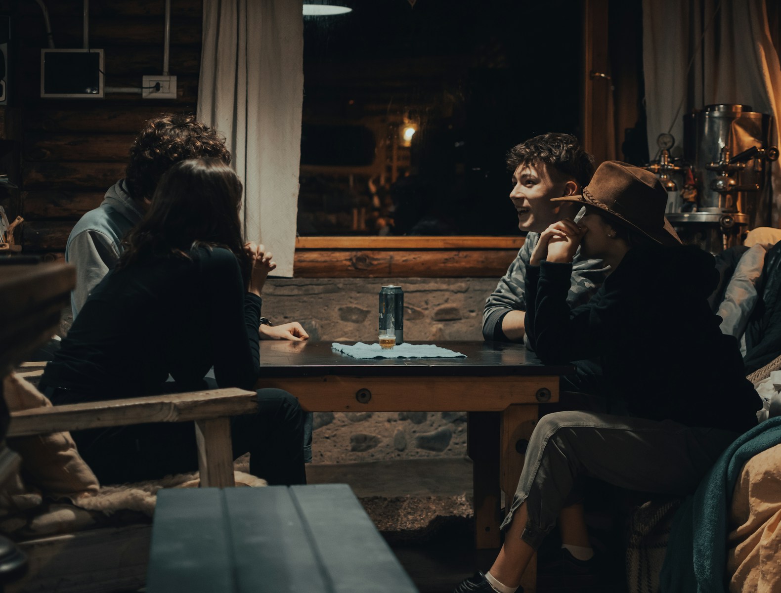 man in black jacket sitting on brown wooden chair