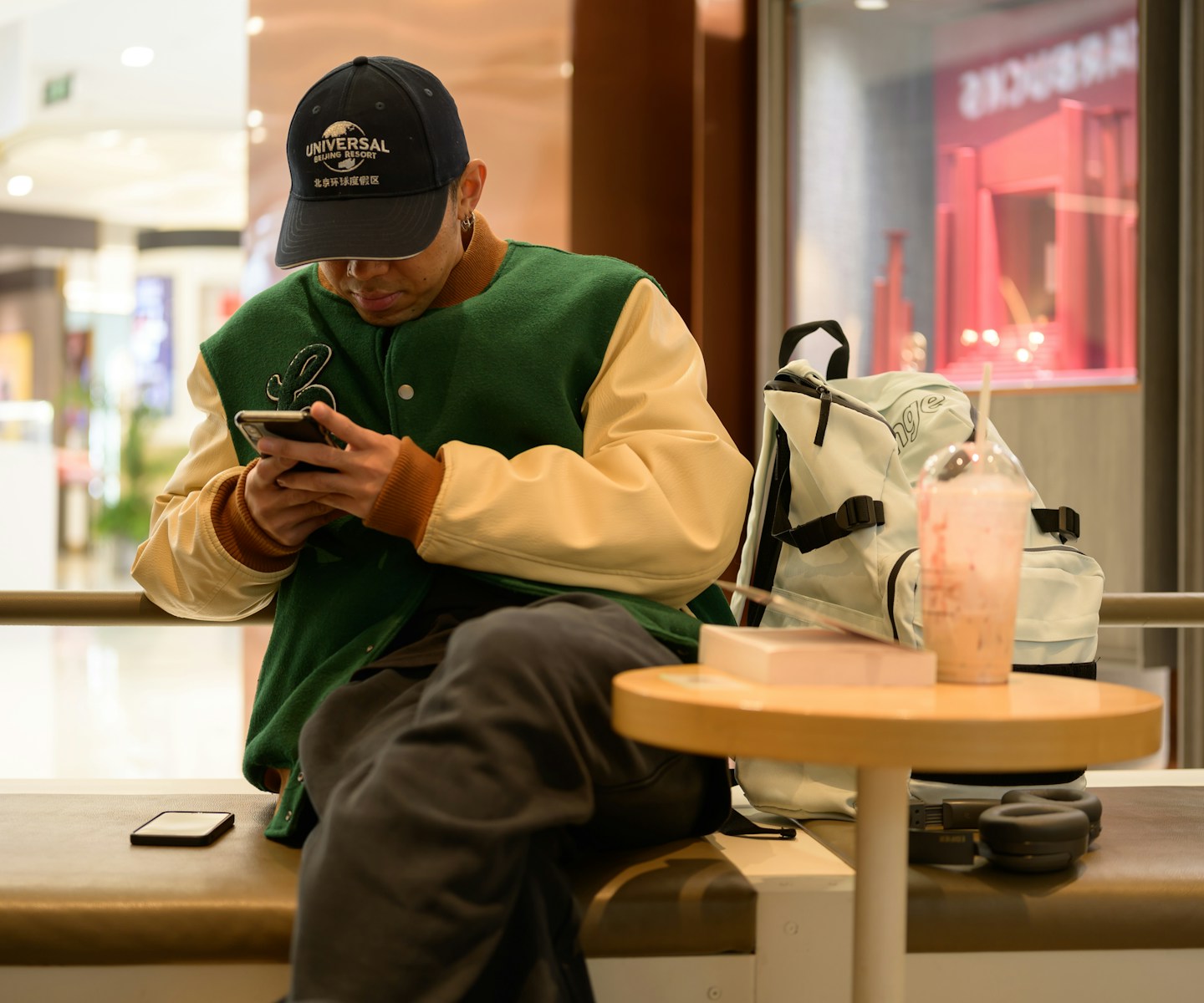 A man sitting on a bench looking at his cell phone