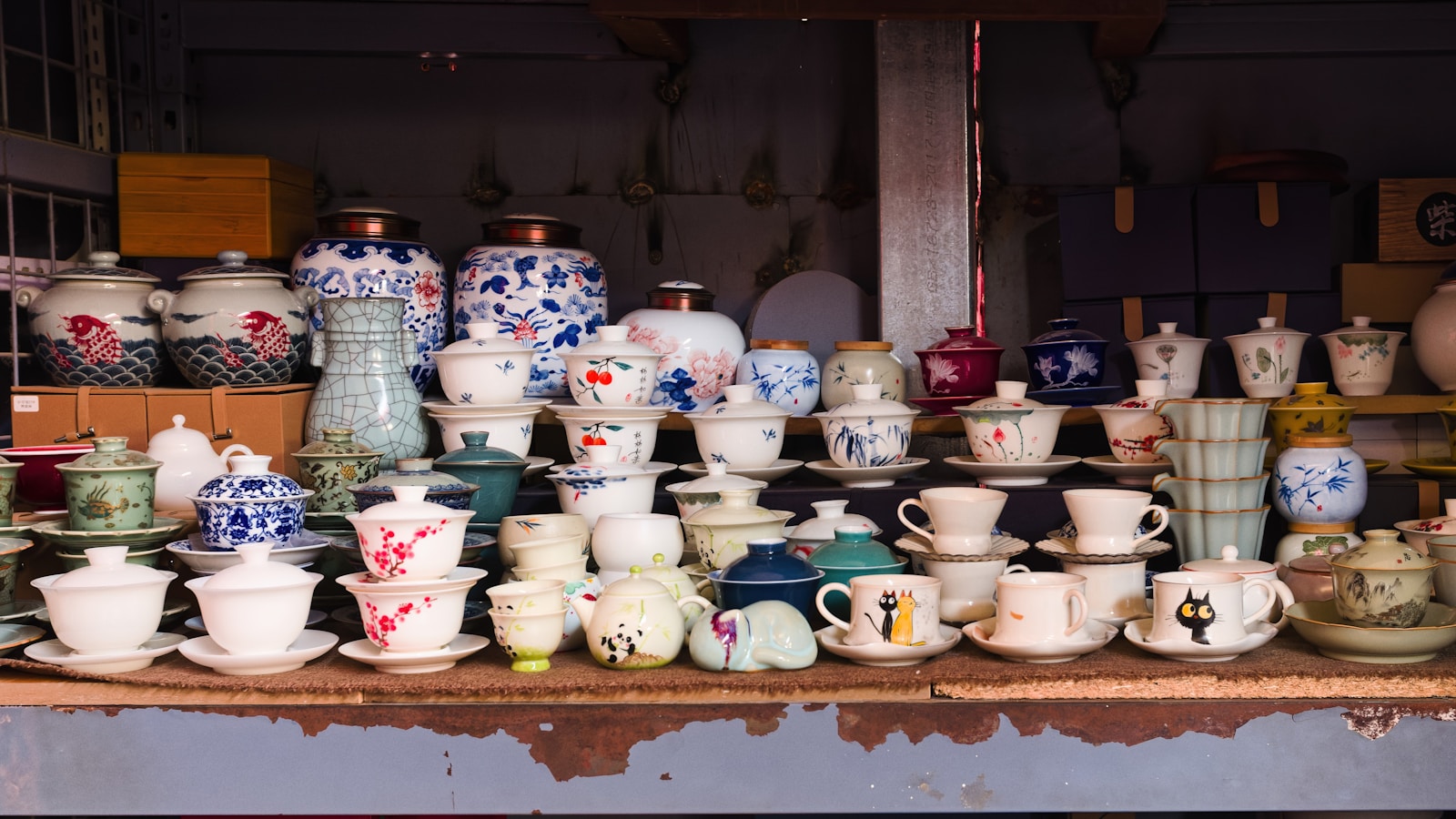 Collection of ceramic teacups and pots on display