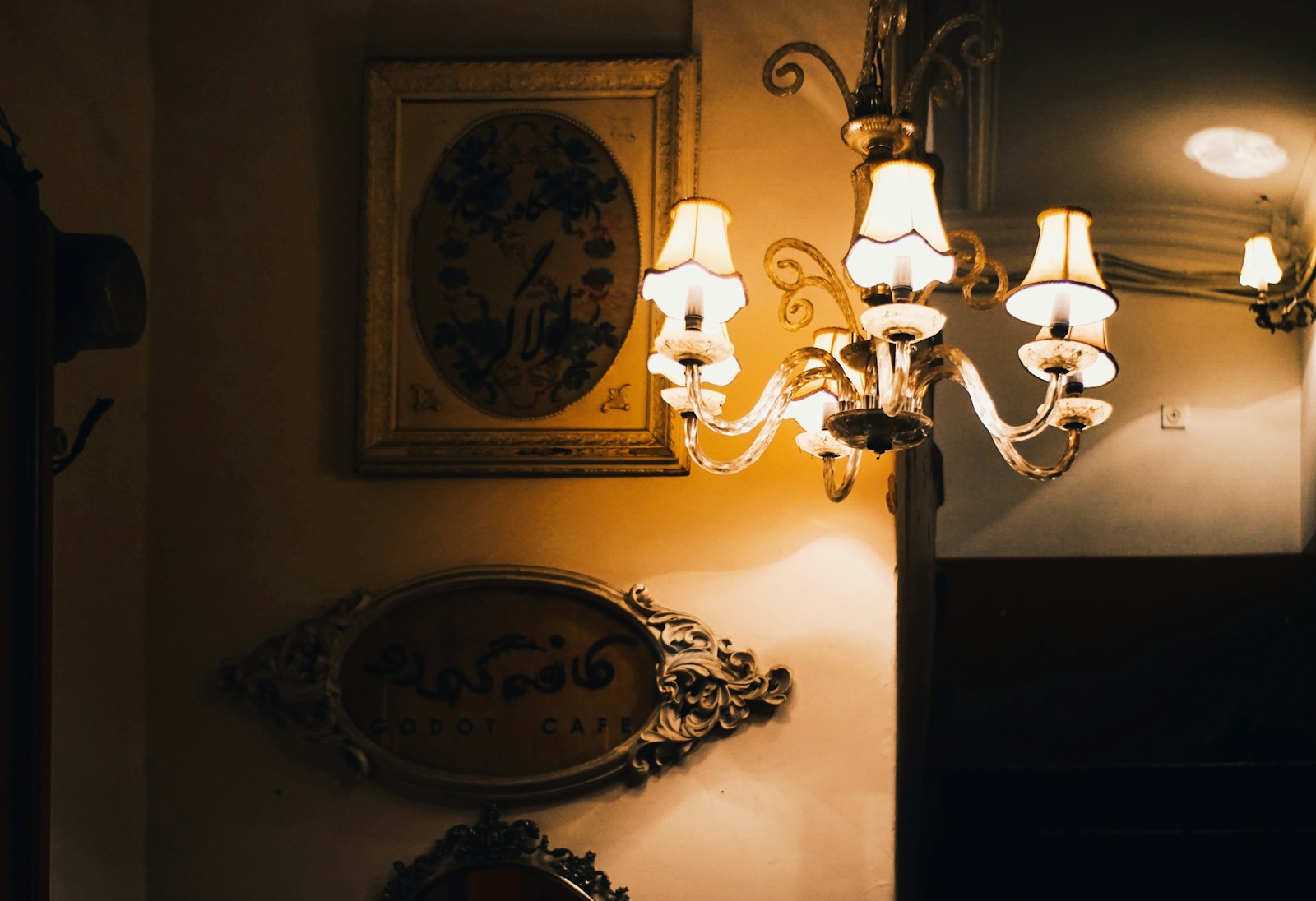 Antique chandelier illuminates ornate wall decorations.