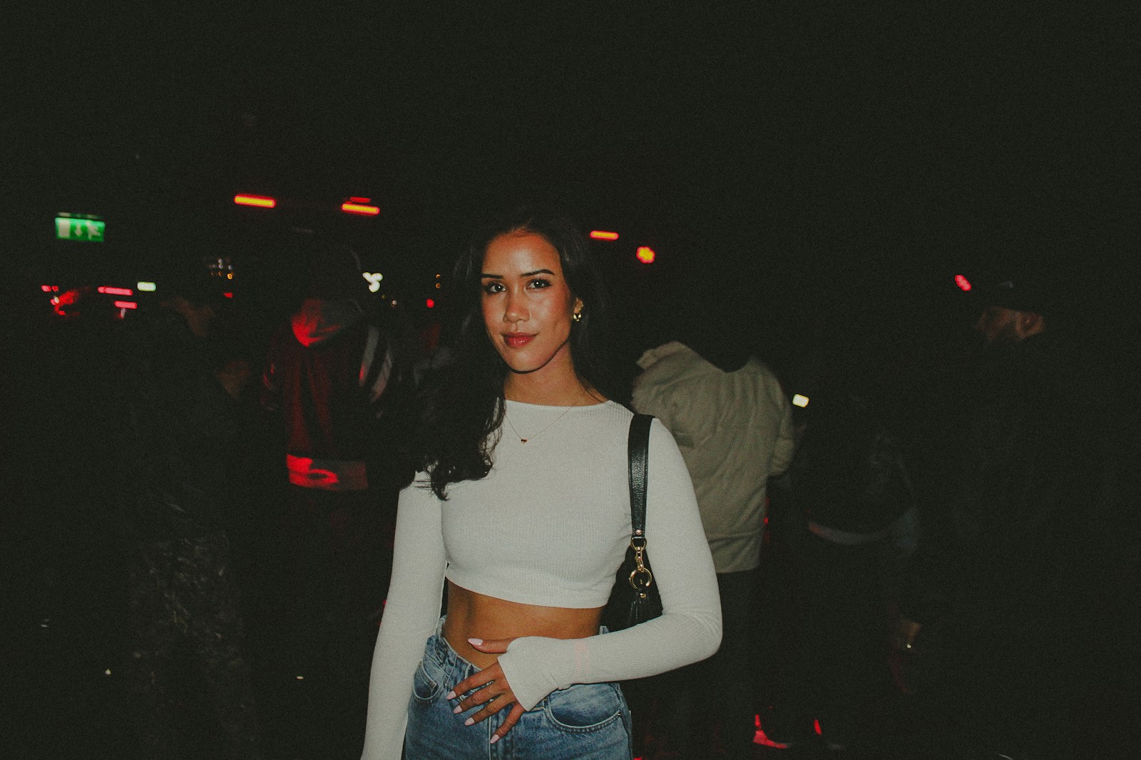 Woman in a white top and jeans at night