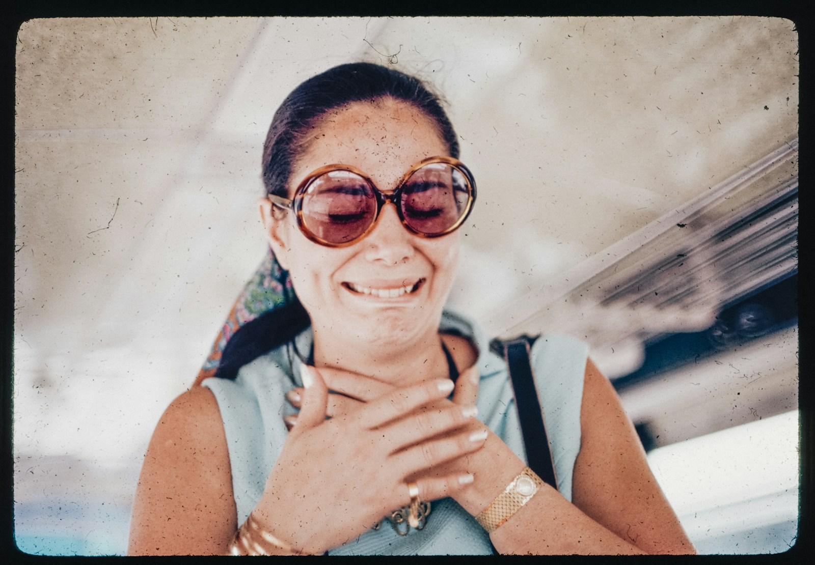 A woman wearing sunglasses is smiling for the camera