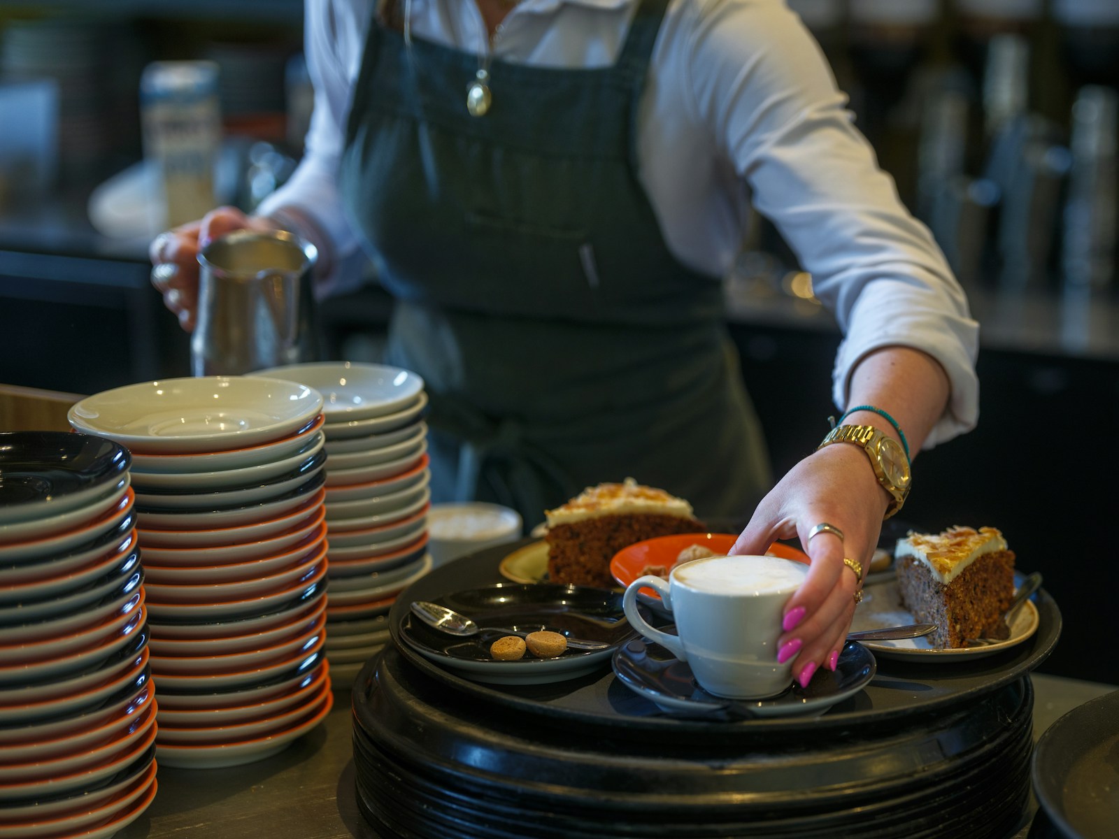 A waitress serves cake and coffee.