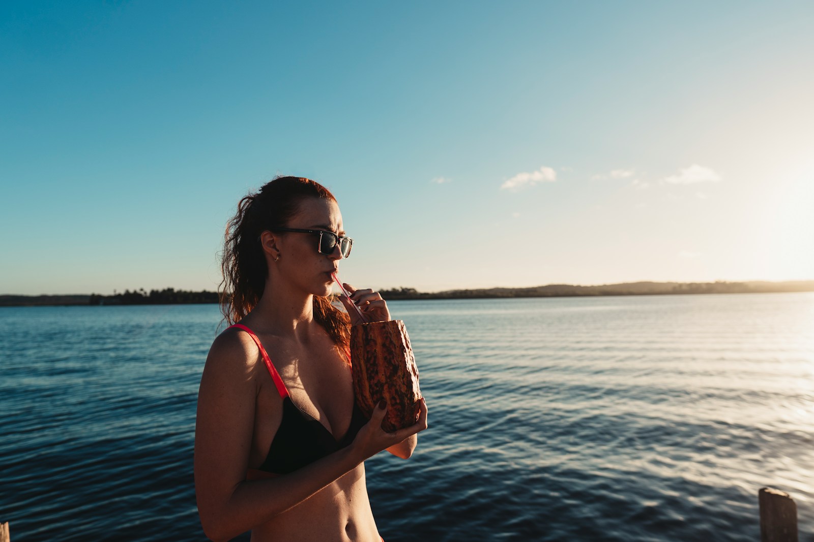 a woman in a bikini holding a baseball glove