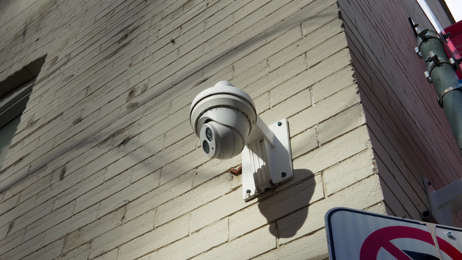 Security camera mounted on a brick wall.