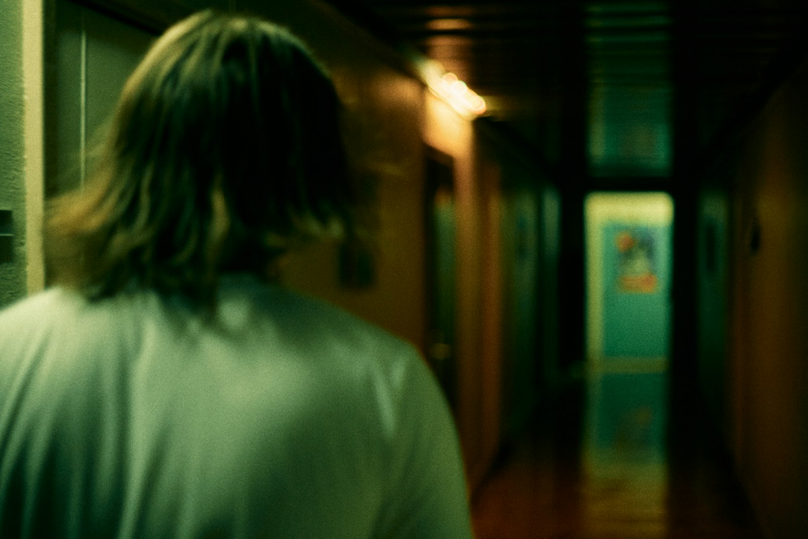 woman in white shirt standing near brown wooden door