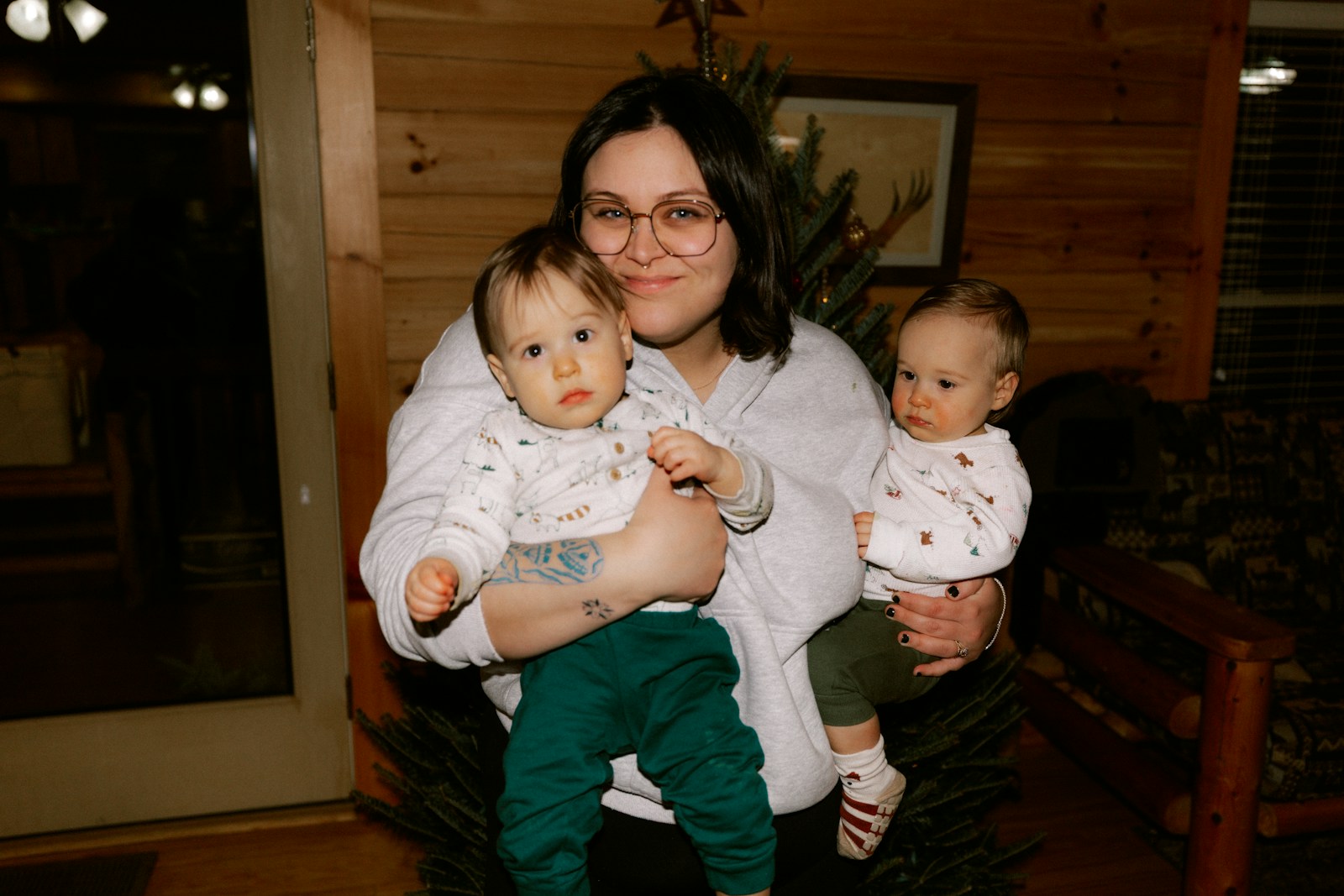 Woman holding two babies in a room