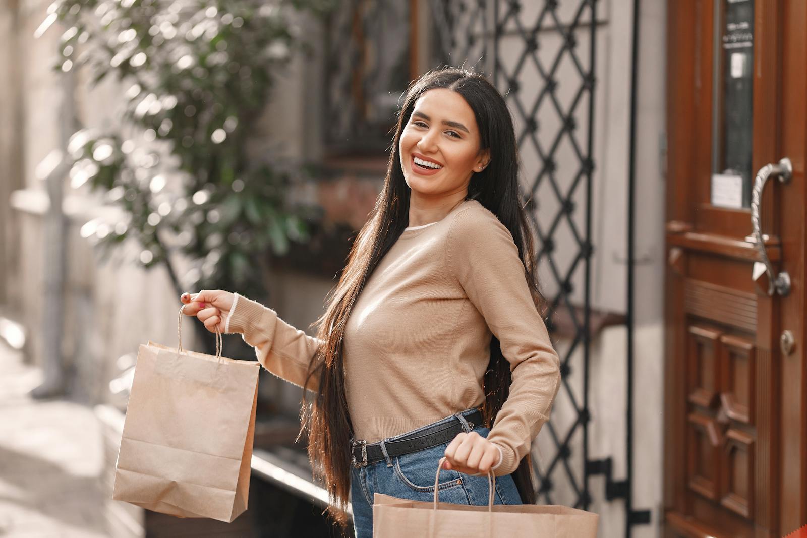 Happy young woman with shopping bags enjoying a sunny day outdoors.