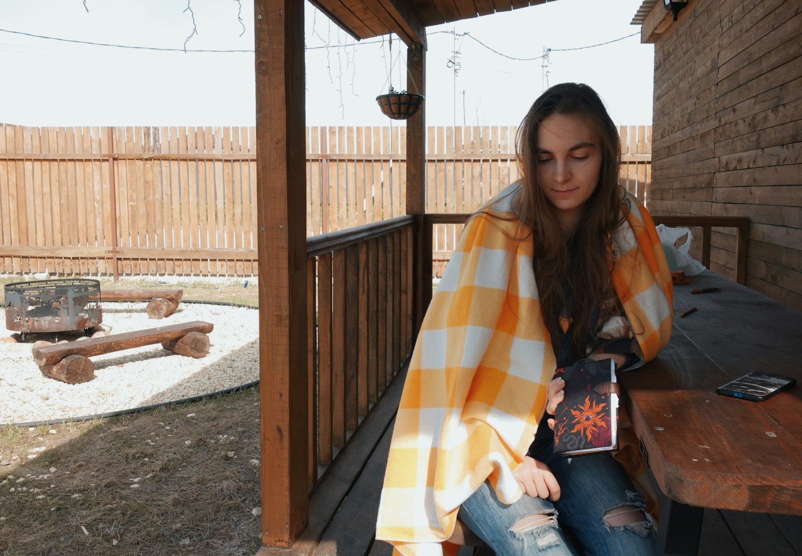 a woman sitting on a porch holding a book
