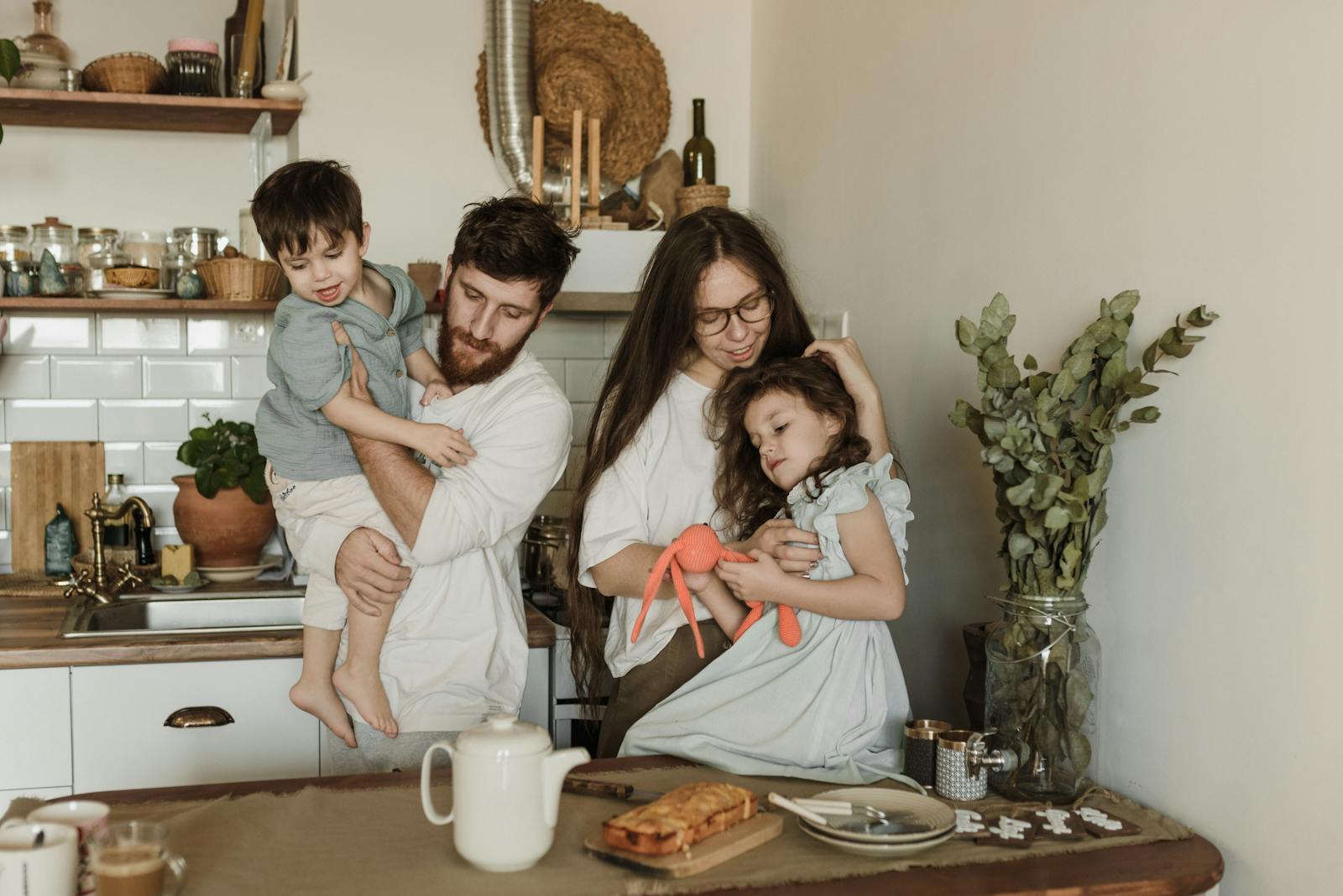 Happy family of four bonding in a warm and cozy kitchen setting, enjoying quality time together.