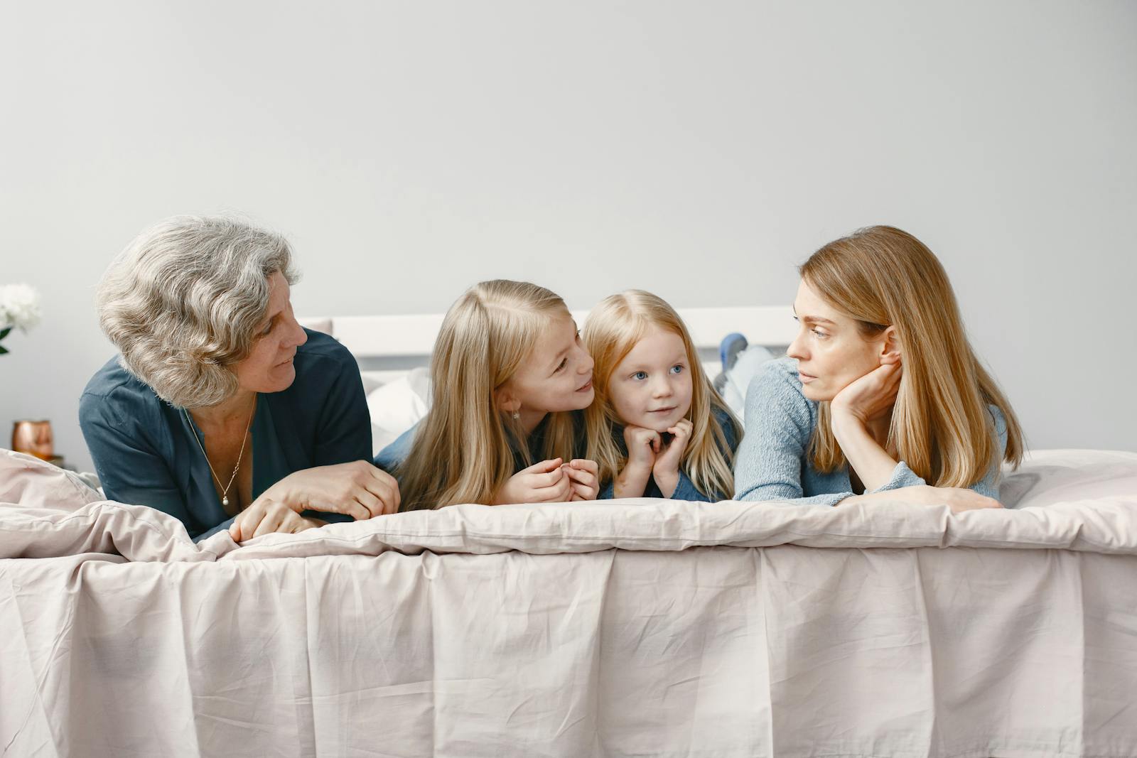 A happy family scene with grandmother, mother, and daughters bonding indoors.