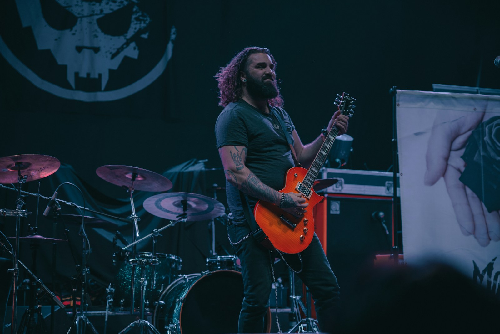 a man with long hair playing a guitar