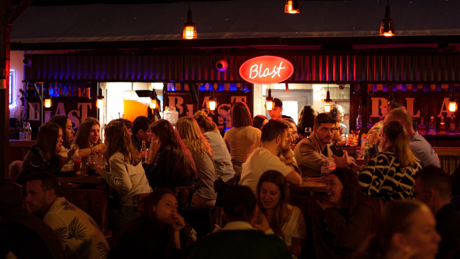 People gathered at a lively bar with neon signs