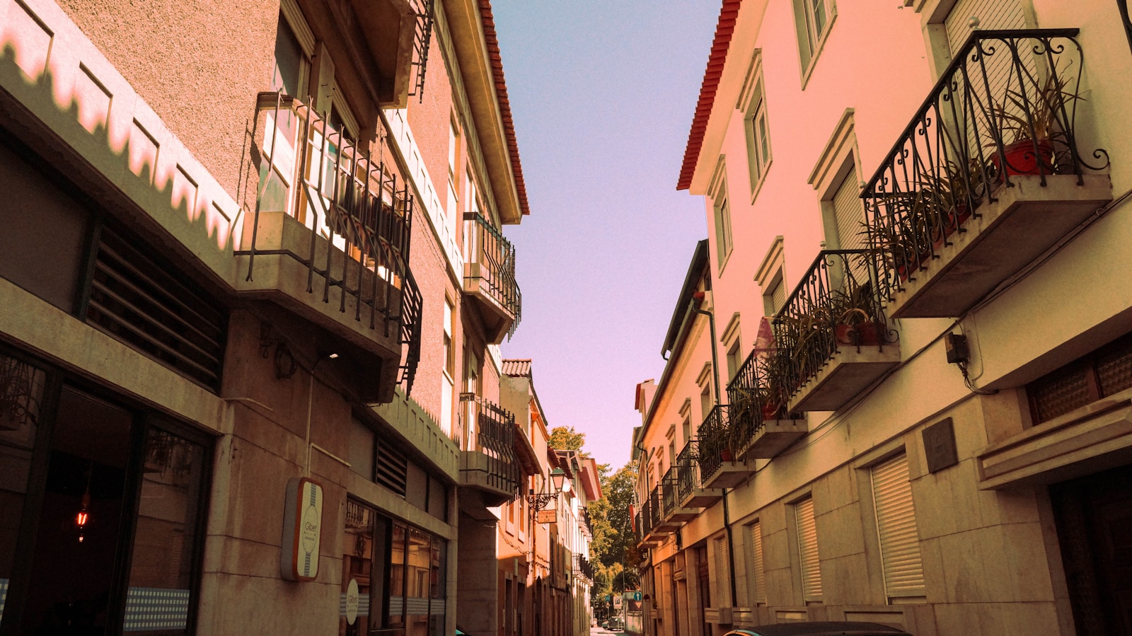 a narrow street lined with tall buildings and balconies