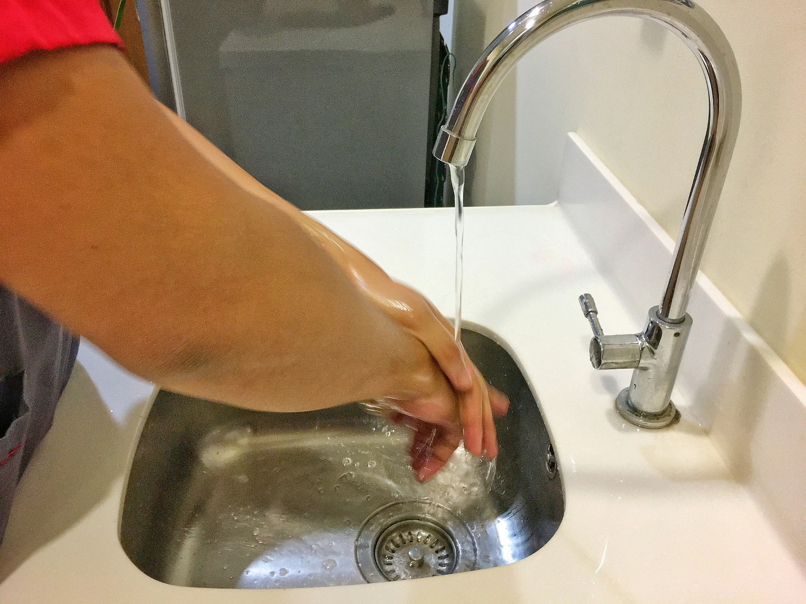 person washing hand on sink