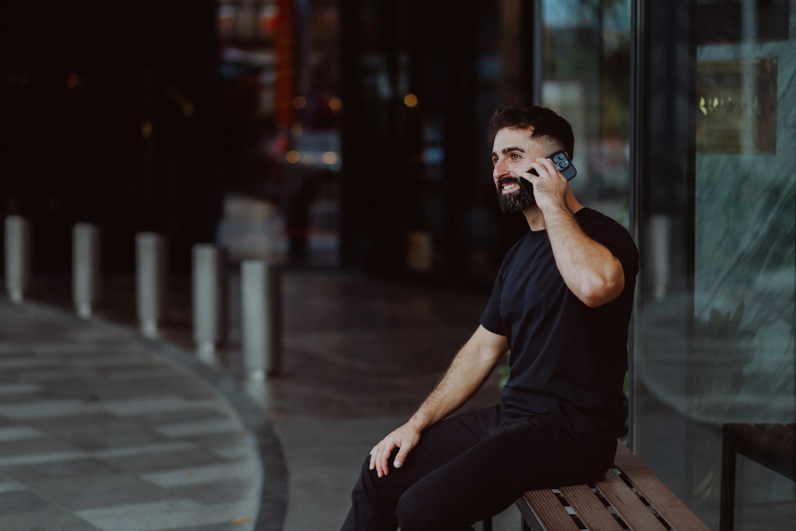 Man in black shirt talking on a smartphone