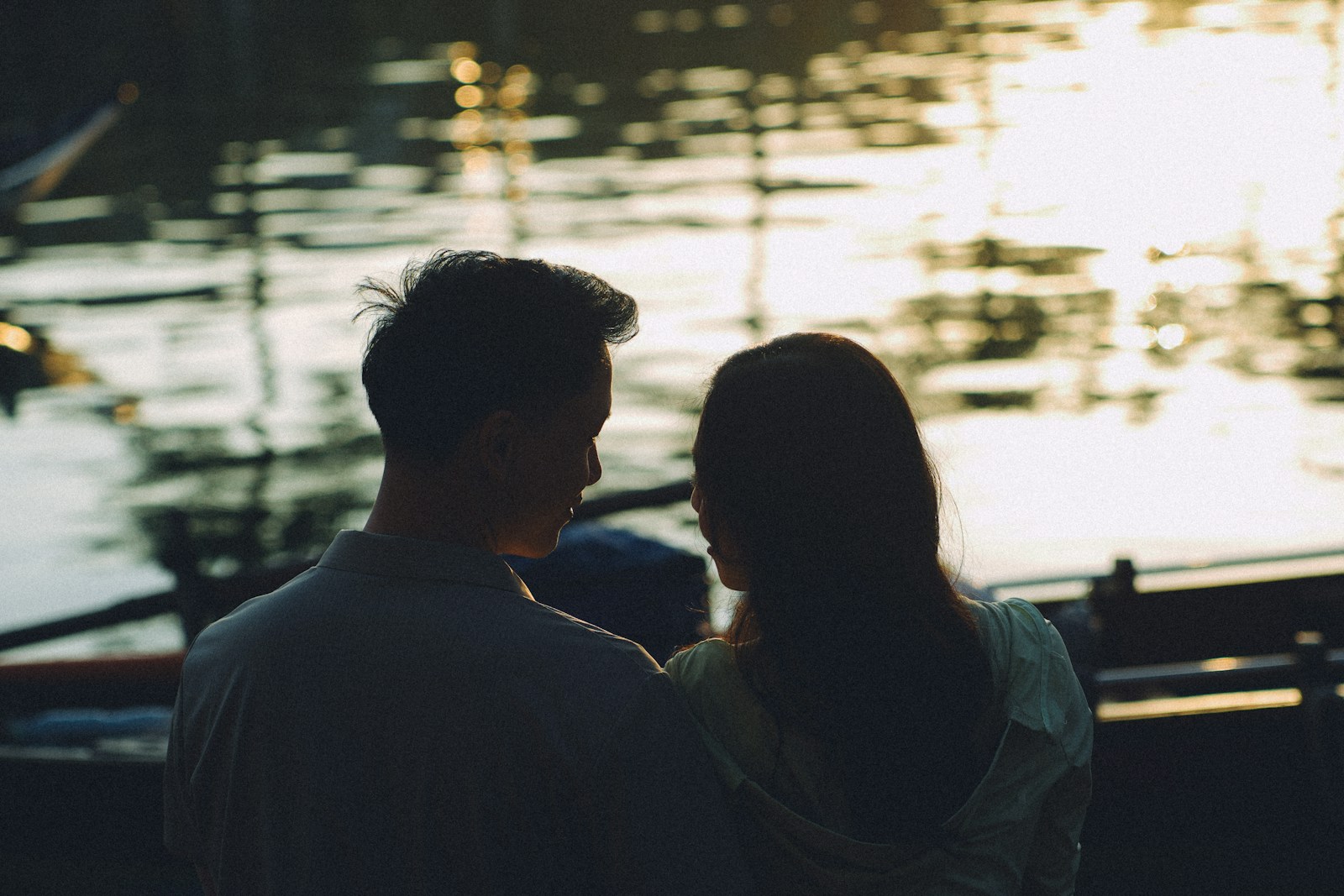 Couple silhouetted against a shimmering water reflection